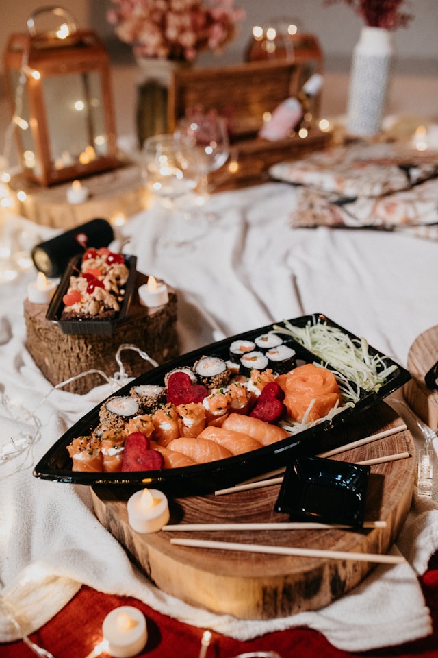 Sushi, losos a bambusové výhonky na svatební tabuli v černé míse
